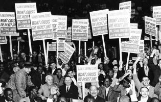 Workers are seen holding signs that read: "The Dress Shipping Clerks' Won't Cross the  	Picket Line. We Stand United with the Dressmakers Union” Photo from 1958.